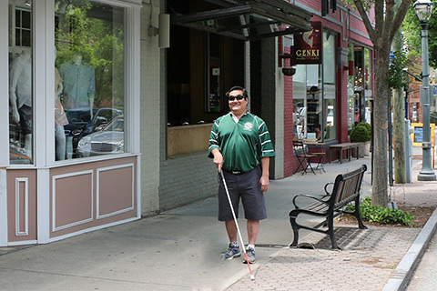 Blind man with cane walking