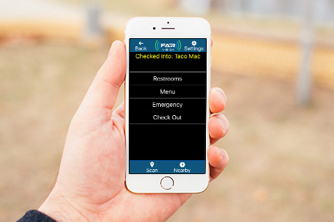 Hand holding phone with FAR Vision app
